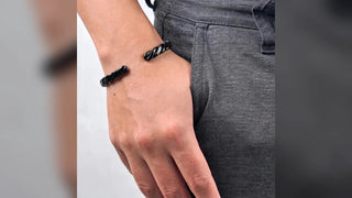 Bracelete masculino preto trançado usado no pulso em imagem horizontal para presente de Dia dos Pais