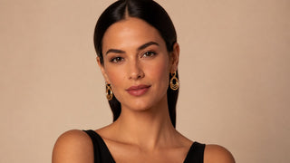 Mulher usando brincos médios dourados com cabelo preso