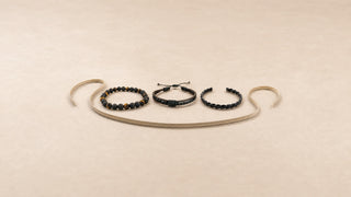 Três pulseiras masculinas da Una com fita métrica sobre fundo bege