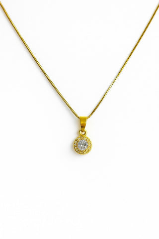 Colar ponto de luz banhado a ouro 18k da UNA Semijoias em fundo branco, com pingente redondo cravejado de zircônias em destaque.