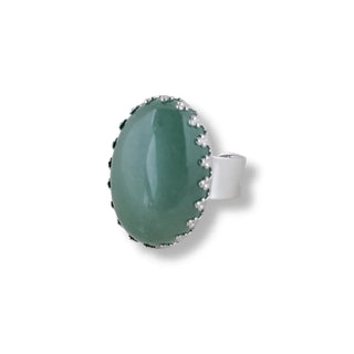 Anel em aço com quartzo verde natural da UNA Semijoias em fundo neutro, acabamento elegante e pedra oval em destaque.