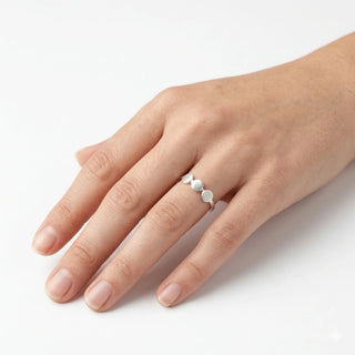 Anel feminino de bolinhas em prata da UNA Semijoias no dedo, design minimalista e moderno em destaque.