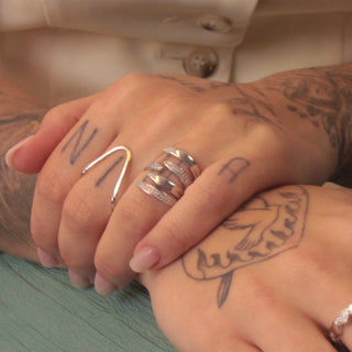 Anel garras cravejado com zircônias banhado a ródio da UNA Semijoias no dedo feminino, design moderno e sofisticado em destaque.