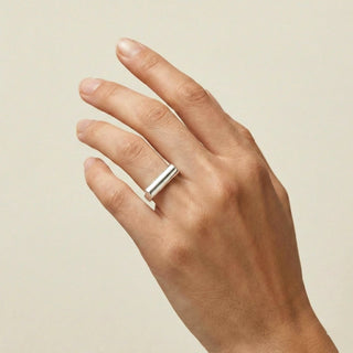 Mão feminina com ANEL REGULAVEL TUBO BANHADO A PRATA 925 em design tubular moderno e minimalista.
