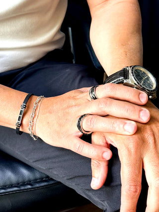 Bracelete masculino de aço inox com silicone preto da UNA Semijoias no pulso masculino em close, acessório moderno e resistente em destaque.