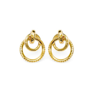 Brinco feminino círculos entrelaçados dourado da UNA Semijoias em fundo branco, com design sofisticado e acabamento texturizado.