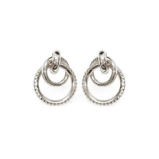 Brinco feminino círculos entrelaçados prateado da UNA Semijoias em fundo branco, com design sofisticado e textura elegante.