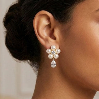 modelo morena de cabelo preso usando brinco de flor de perolas banhado a ouro 18k