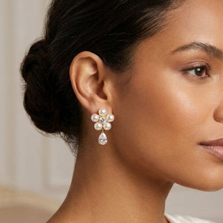 modelo morena de cabelo preso usando brinco de flor de perolas banhado a ouro 18k