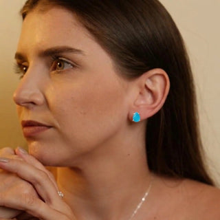 Brinco gota azul banhado a prata 925 da UNA Semijoias na orelha feminina, peça elegante e delicada para o dia a dia.