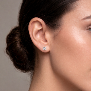 Mulher usando BRINCO PONTO DE LUZ delicado e brilhante em tom prata, estilo minimalista e elegante.