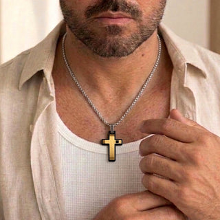 Colar de aço masculino da UNA com pingente de cruz dourada no pescoço do modelo. acessório sofisticado para o dia a dia