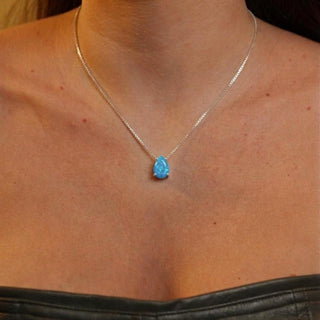Colar feminino com pingente gota azul banhado a prata 925 da UNA Semijoias no colo, destaque para pedra azul delicada e elegante.