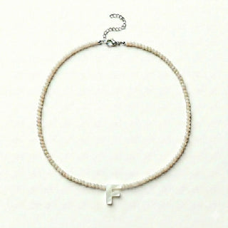 COLAR CRISTAL COM LETRA EM RESINA com contas claras e letra F em destaque, delicado e elegante.