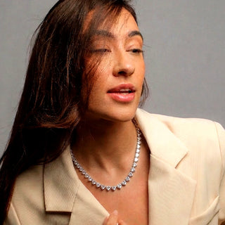 Colar riviera de 3 pontas banhado a ródio da UNA Semijoias no colo feminino, em produção sofisticada com blazer claro
