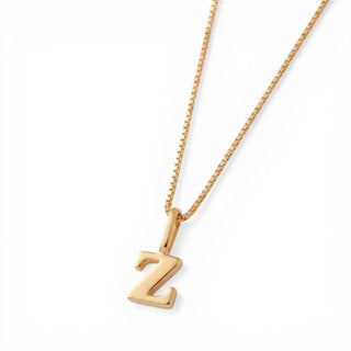 Colar Sign com pingente letra banhado a ouro 18k da UNA em corrente veneziana e fundo branco