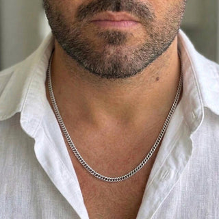 Corrente de aço masculina elo grumet fino da UNA usada no pescoço em foto editorial, acessório versátil para o dia a dia