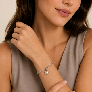 Pulseira com coração liso banhada a prata 925 da UNA no pulso feminino, compondo um look elegante para o dia a dia.