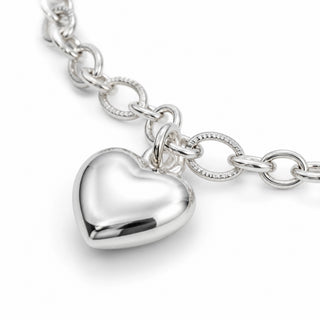 Pulseira Coração Liso G banhada a prata 925 da UNA em close, com pingente polido e elos prateados em destaque.