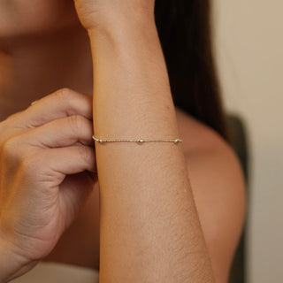 Pulseira delicada com esferas pequenas banhada a prata 925 da UNA Semijoias em fundo branco, em vista frontal.