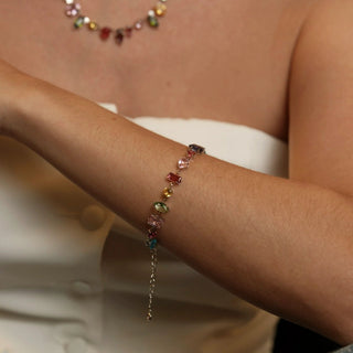 Pulseira mix de pedras de vidro coloridas banhada a ouro da UNA Semijoias no pulso feminino em close, com destaque para as pedras.