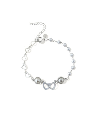 Pulseira com pérolas e pingentes de corações duplos banhada a prata 925 da UNA Semijoias em fundo branco, em vista frontal.