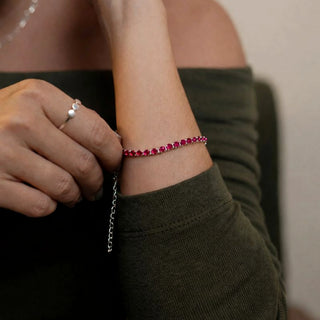 Pulseira riviera rosa banhada a prata 925 da UNA Semijoias no pulso feminino em close, com corrente ajustável e acabamento delicado em destaque.