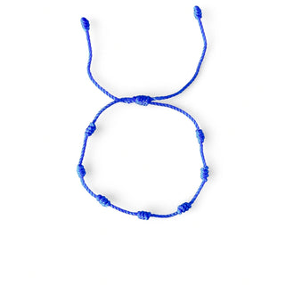 Pulseira verão nozinho da sorte azul da UNA Semijoias em fundo branco, com cordão ajustável e nós distribuídos ao longo de toda a pulseira.