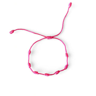 Pulseira verão nozinho da sorte rosa da UNA Semijoias em fundo branco, com cordão rosa ajustável e nós delicados distribuídos pela pulseira.